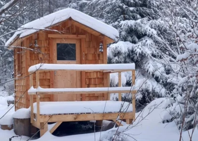 Sauna en bois Essentiel Bois Adejo Sàrl dans un paysage enneigé