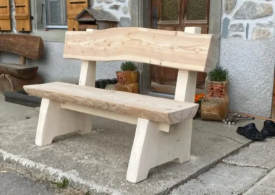Banc artisanal en bois massif posé devant une maison en pierre – Essentiel Bois Adejo Sàrl