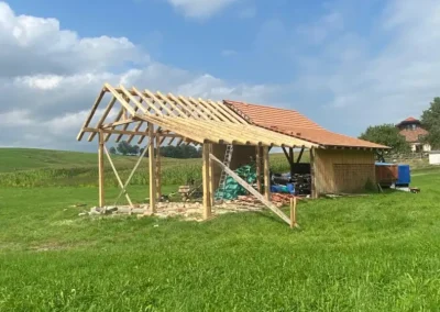Extension de charpente bois en cours de construction sur terrain agricole – Essentiel Bois Adejo Sàrl
