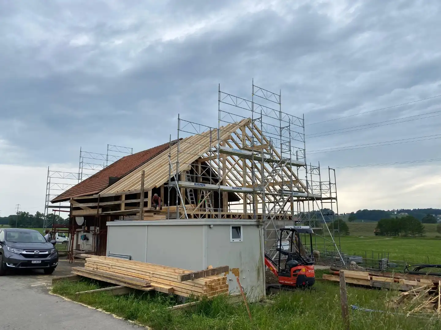 Pose d’une charpente bois avec échafaudage sur bâtiment en rénovation – Essentiel Bois Adejo Sàrl
