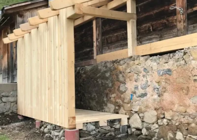 Construction d’un petit auvent en bois adossé à un mur en pierre – Essentiel Bois Adejo Sàrl